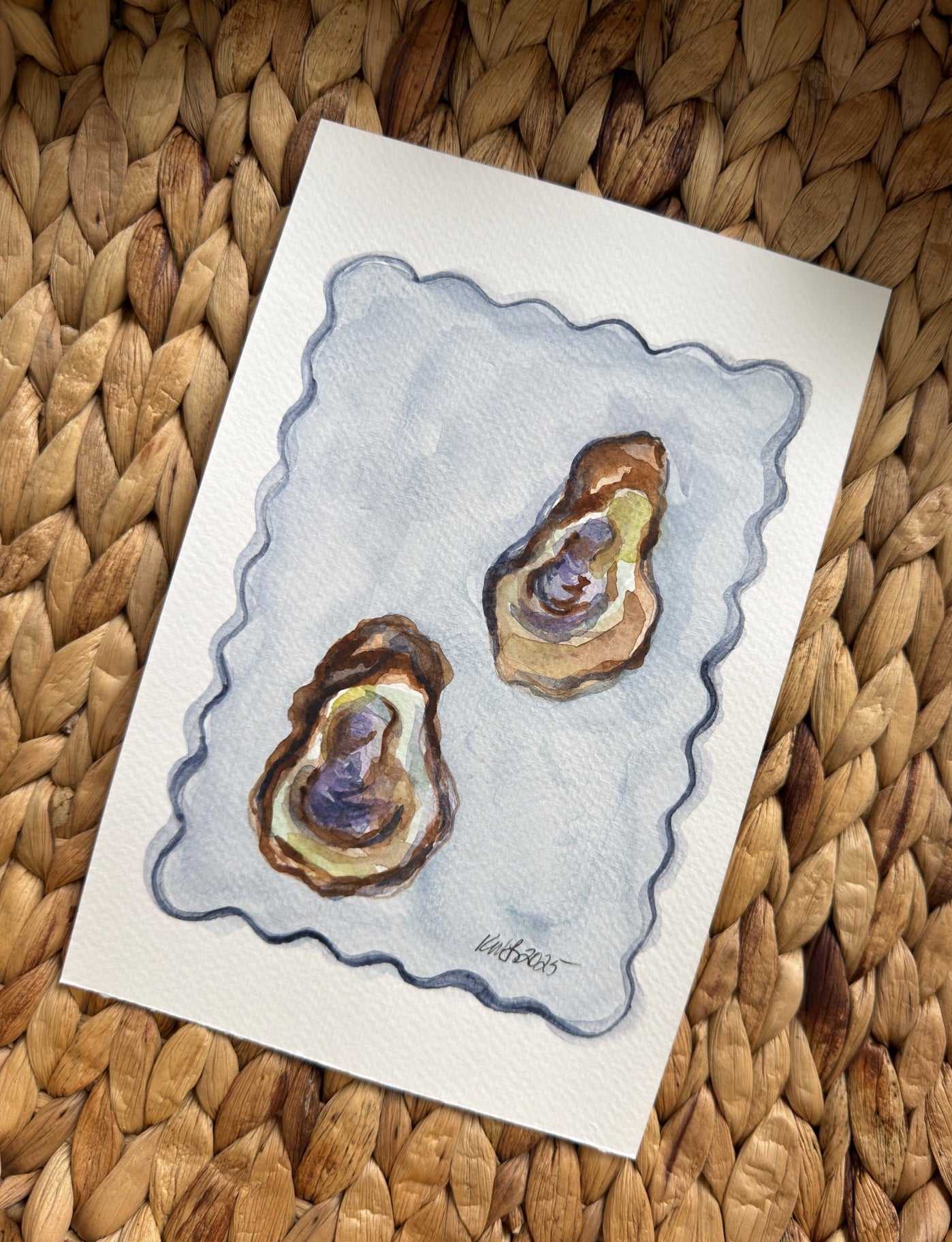 Card with a drawing of two oysters on a textured woven surface